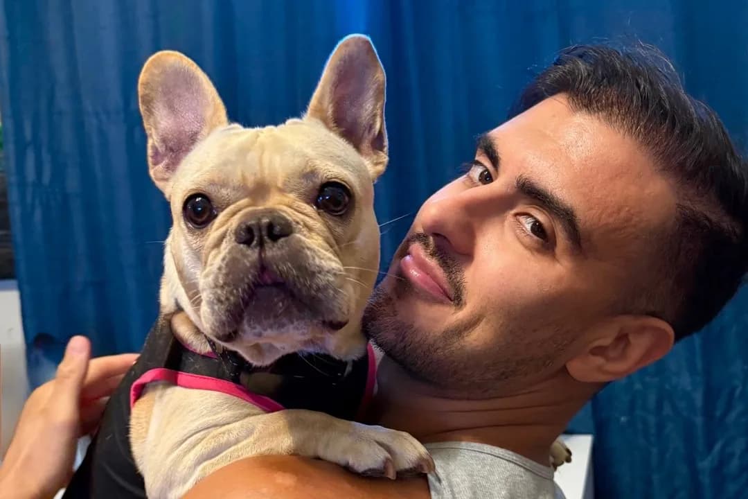 Tyler holding Angel, a French Bulldog guest, over his shoulder at his home in Lathrop